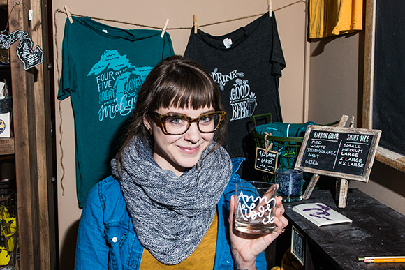 Kristen Drozdowski with shirts and glasses she designed