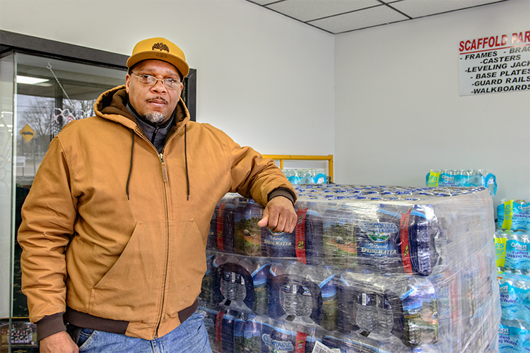 Bryan Foley at Delux Rental with water collected for Flint