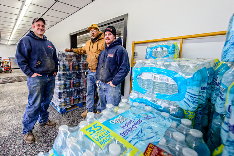 Shawn Scott, Bryan Foley and Paul Irwin at Delux Rental with water collected for Flint