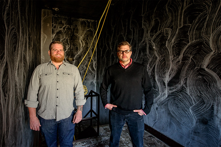 Jesse Kranyak and Mark Maynard in the smoke damaged starewell of Landline Creative Labs