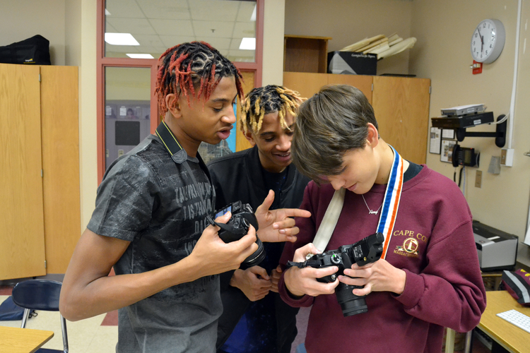 Leland Spratt, Lemuel Spratt, and Teilo Wessells look at their shots together.