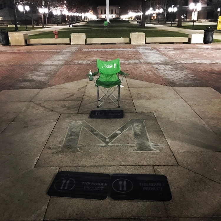 An Edible Project camp chair and doormats on the University of Michigan Diag.