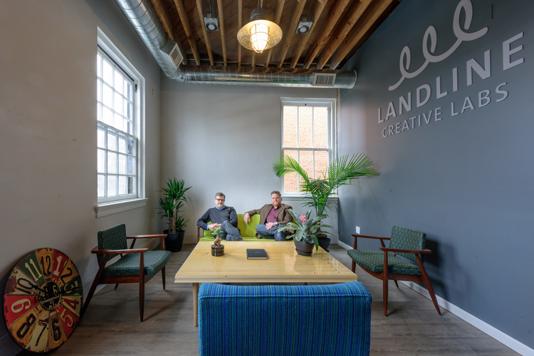 Mark Maynard and Jesse Kranyak sit on the couch in Landline Creative Labs' lobby.