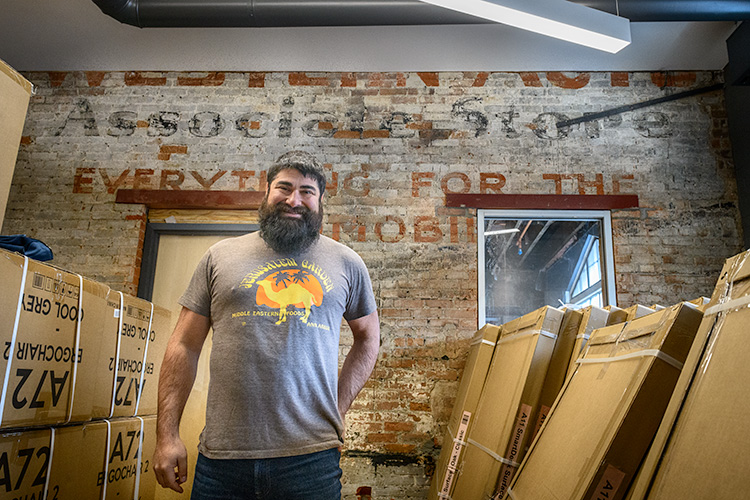 Joe Malcoun in front of the old Western Auto Associate Store sign at Cahoots