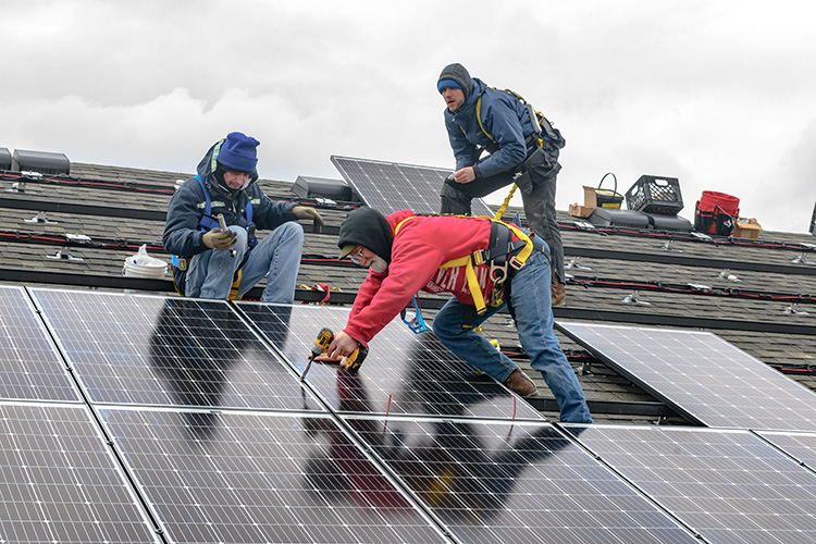 Installing solar panels on the Amos Washington Building at New Parkridge