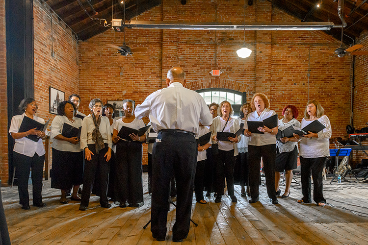 Our Own Thing Chorale performs for Bridging 23 participants at the Ypsilanti Freighthouse