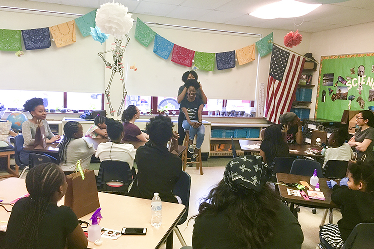 Breon Canady from Original Moxie gives a demonstration on hair care at a Village Project event.