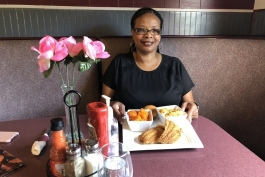 Andrea "Cuppy" White shows off a plate of food at Cuppy's Best Soulful Cafe.