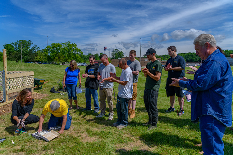 Recovery court program participants applaud as Dale Booth creates a stepping stone.