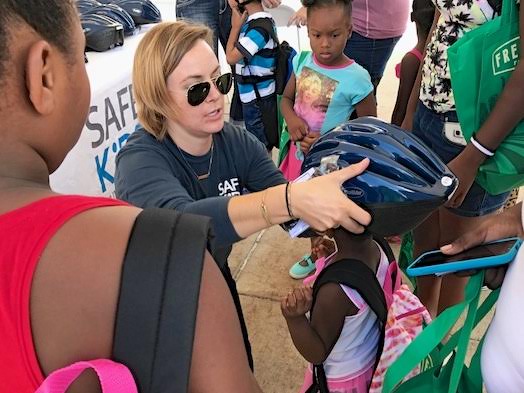 Safe Kids Huron Valley staffers fit kids for bike helmets at last year's Healthy Kids Fair.