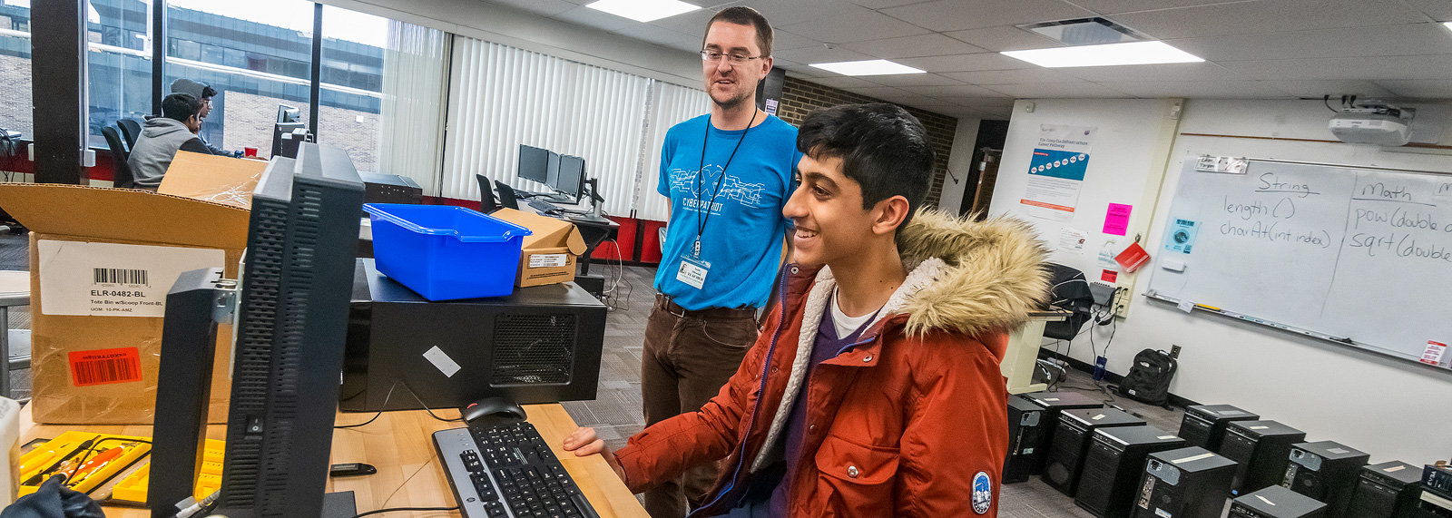 Teacher Scott Obsniuk advises a student with the Canton High School CyberPatriots