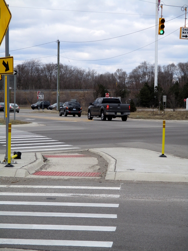 The intersection of Michigan and Dorset Avenues. A knocked-over barrier is visible in the pedestrian island.