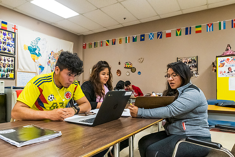 Diana Bernal-Canseco (right) of Buenos Vecinos helping students in an ESL class at YCHS.