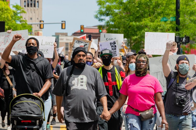 Dan Grady El and Sha'Teina Grady El (center) march hand in hand.