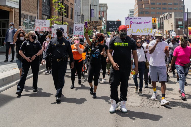 Protestors, joined by Ann Arbor Police Chief Michael Cox (in police uniform and cap), march through Ann Arbor.