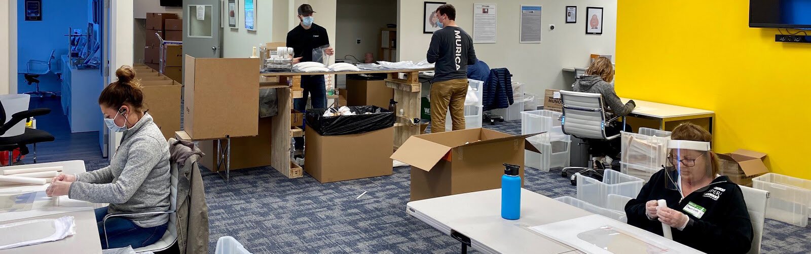 Akervall Technologies employees assemble face shields.