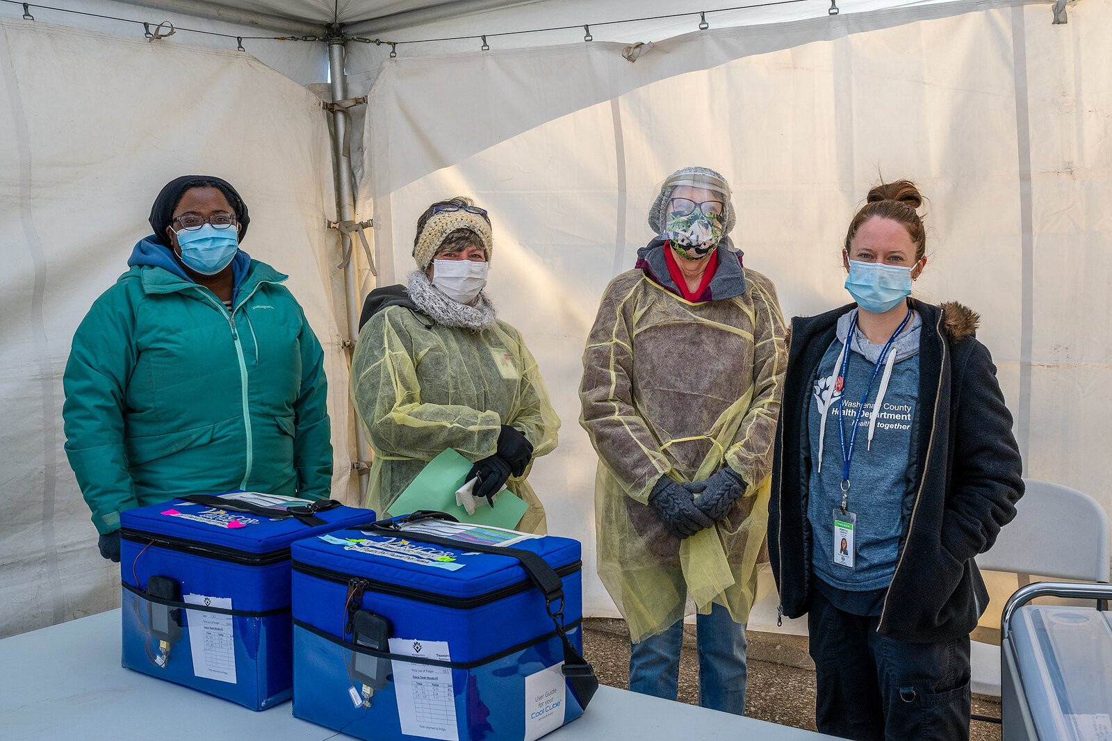 Charlyn VanDeventer, Carrie DeJonghe, Jayne Worthy-Howlett, and Rebecca Longhany work a drive-through/walk-up flu shot event in the Washtenaw County Health Department parking lot in Ypsilanti.