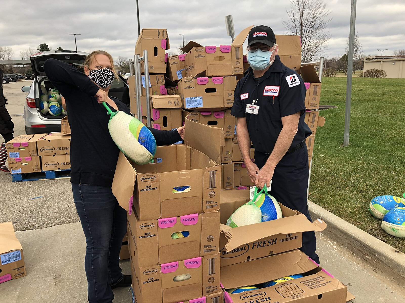 Hope Clinic and Costco staff load turkeys into a car.