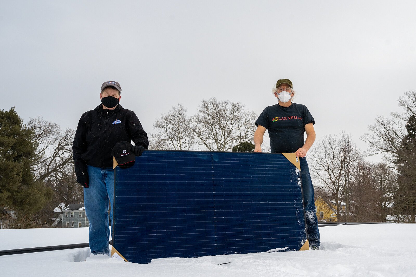 AJ Leo Electric & Solar owner Amy Strutz and Solar Ypsi founder Dave Strenski installing a solar panel on the Rutherford Pool bath house.