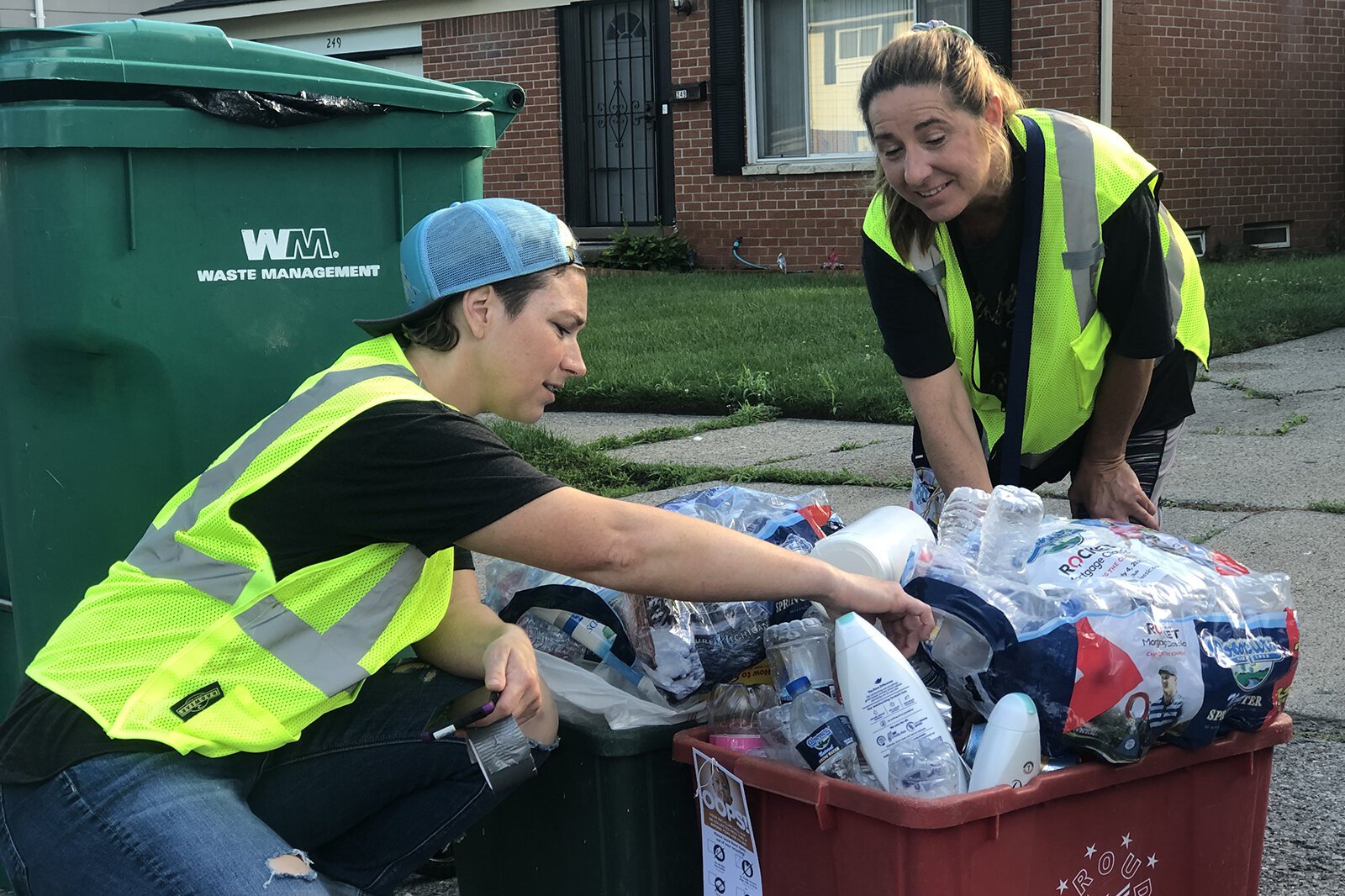 WRRMA-trained cart inspectors Laurena Deak and Julie Cline examine recycling bins in Ypsilanti Township.