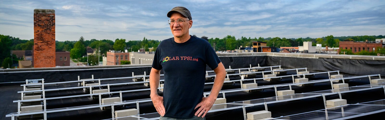 Solar Ypsi founder Dave Strenski stands among the solar panels on the roof of Riverside Arts Center in Ypsilanti.