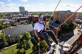 A participant at last year's Over the Edge event prepares to rappel down the Graduate Hotel.