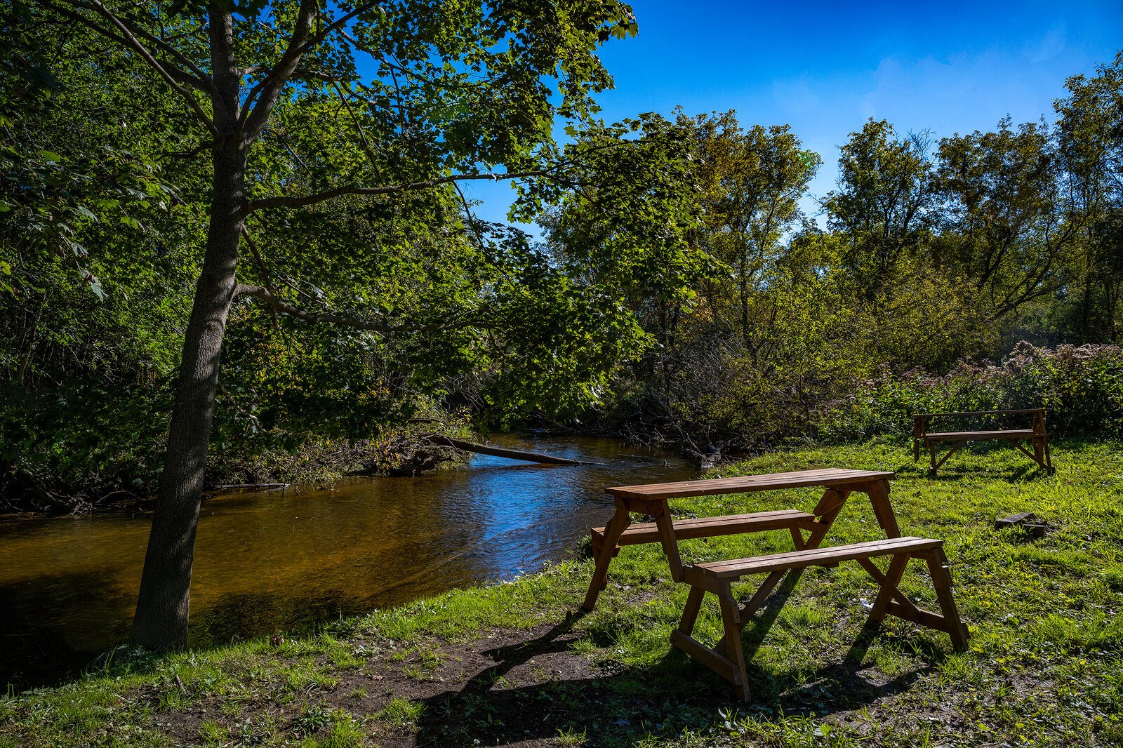 Picnic tables by Fleming Creek behind The Boro.