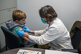 Alexander Lee recieves his COVID vaccine from Steve Jensen at Daycroft School.