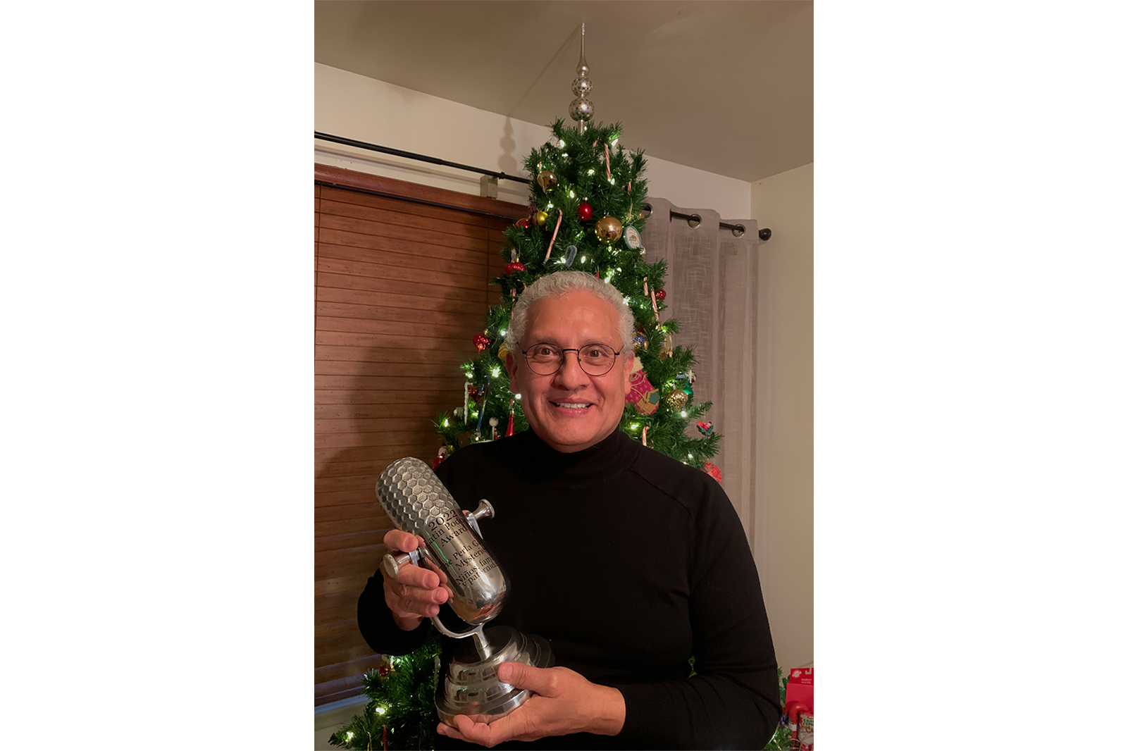 Rudy Alvarado with the trophy he won from the Latin Podcast Awards.