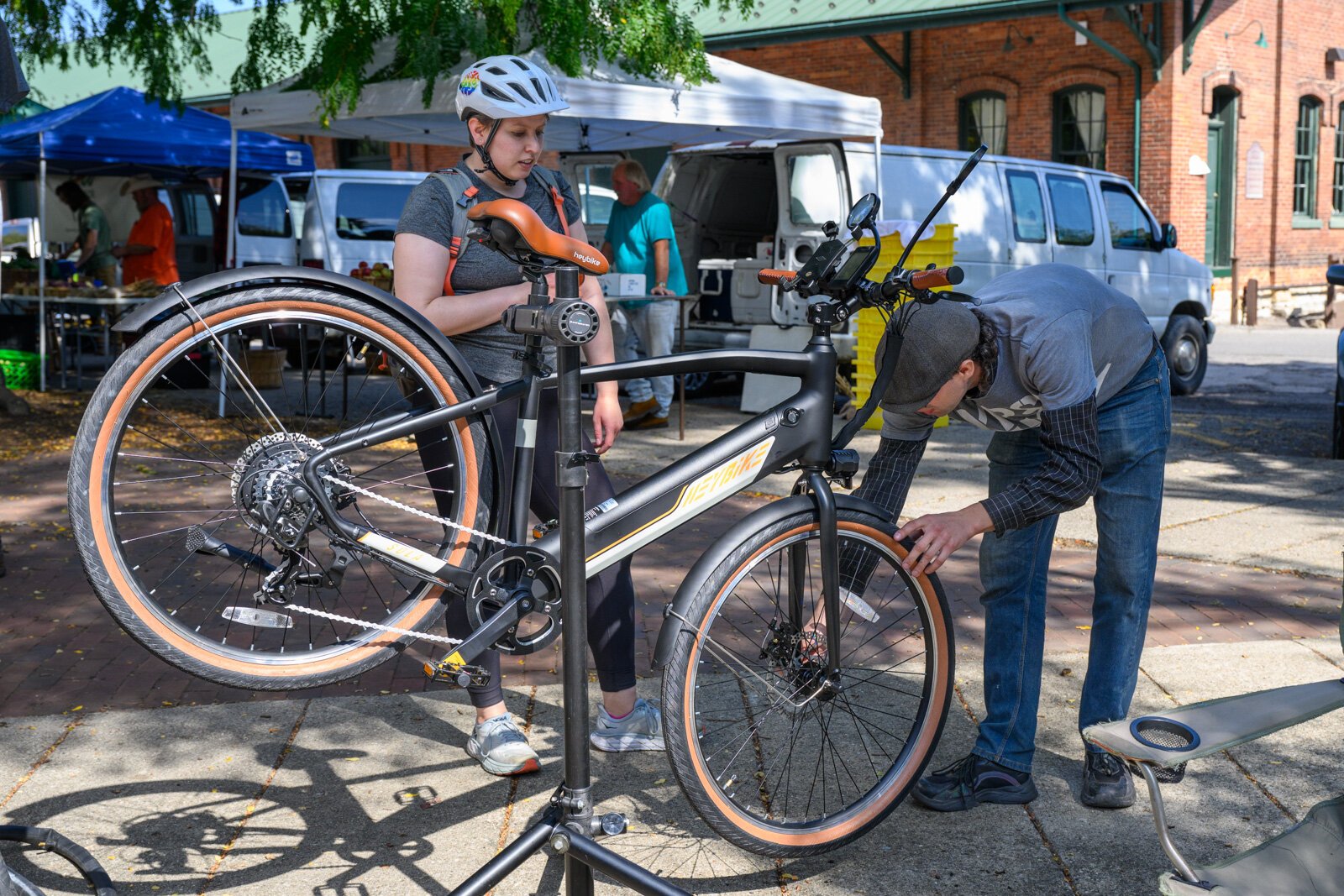 Anthony Lutz repairing a bike at the Ypsi Bike Co-op's booth at Ypsilanti's Depot Town farmers market.