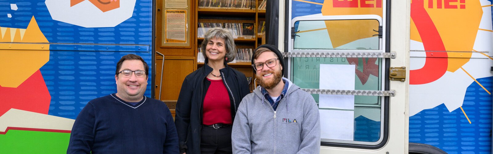 Sam Killian, Lisa Hoenig, and Aaron Smith at the bookmobile outside of the Ypsilanti District Library Michigan Avenue branch.