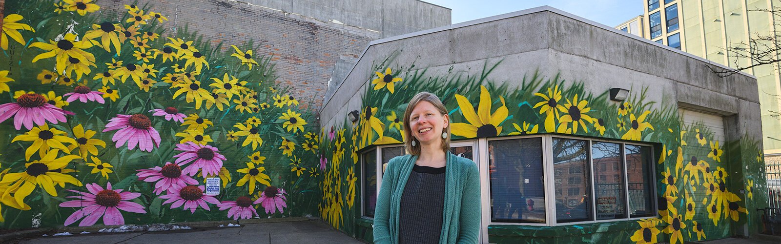 Hannah Kirkpatrick in front of Ouizi's "Drift" mural.