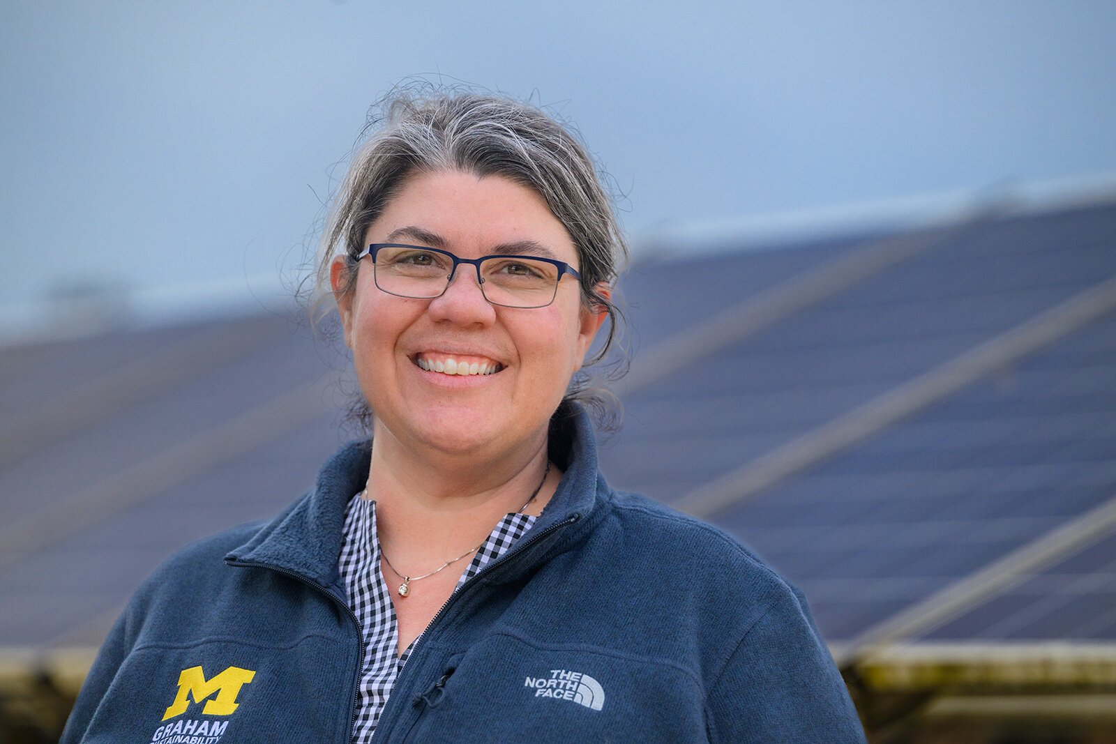 Sarah Mills in front of solar panels on U of M's North Campus.
