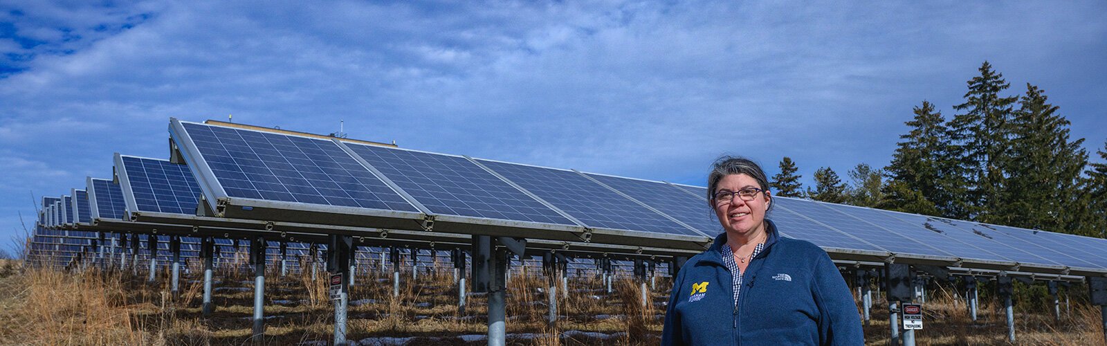 Sarah Mills in front of solar panels on U of M's North Campus.