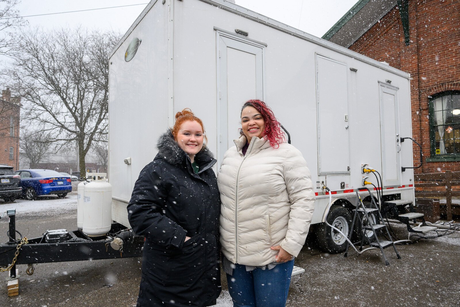 Kate Holcomb and Tajalli Hodge with the WashUp Ministries mobile shower facility at the Ypsilanti Freighthouse.