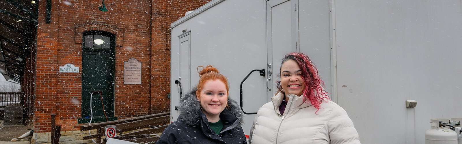 Kate Holcomb and Tajalli Hodge with the WashUp Ministries mobile shower facility at the Ypsilanti Freighthouse.