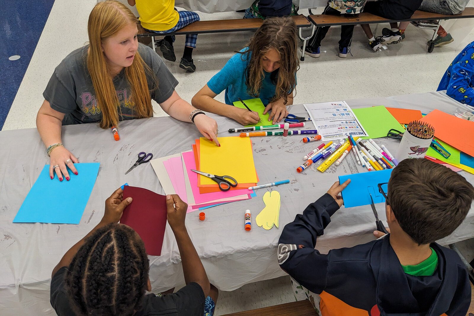 Stamps School students helping YIES students work on artwork for their capstone projects.