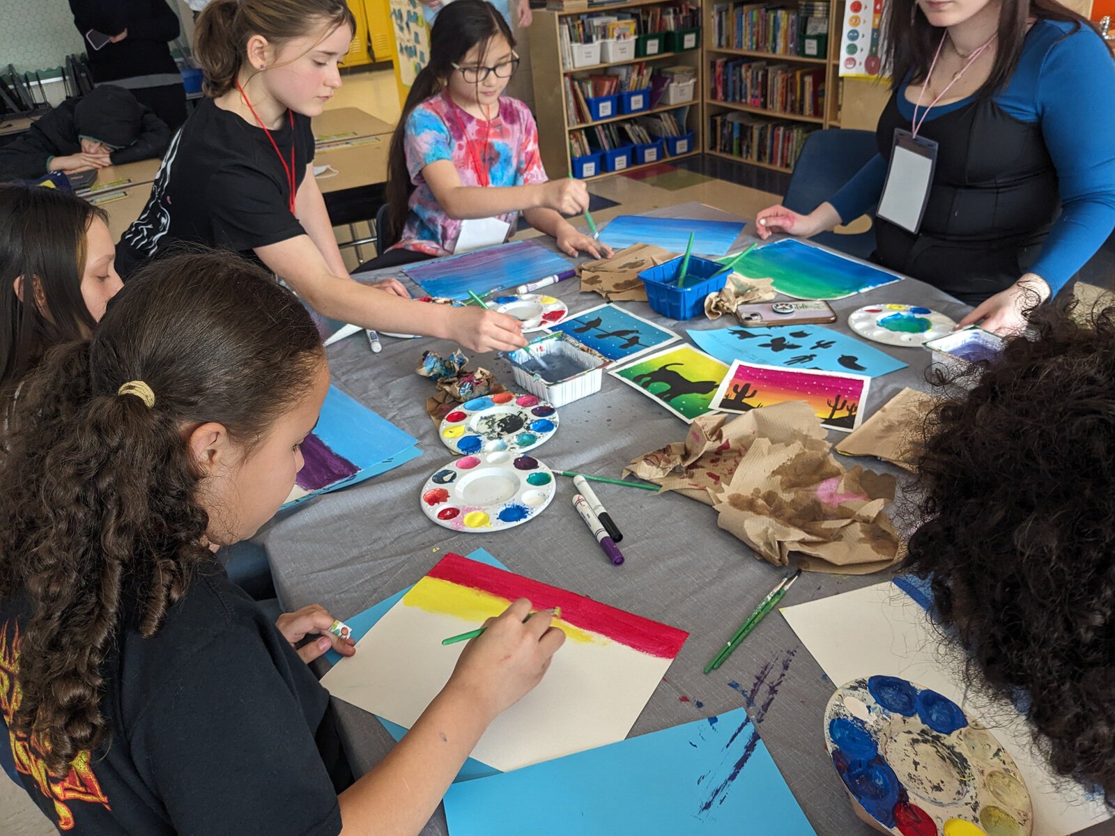 Stamps School students helping YIES students work on artwork for their capstone projects.