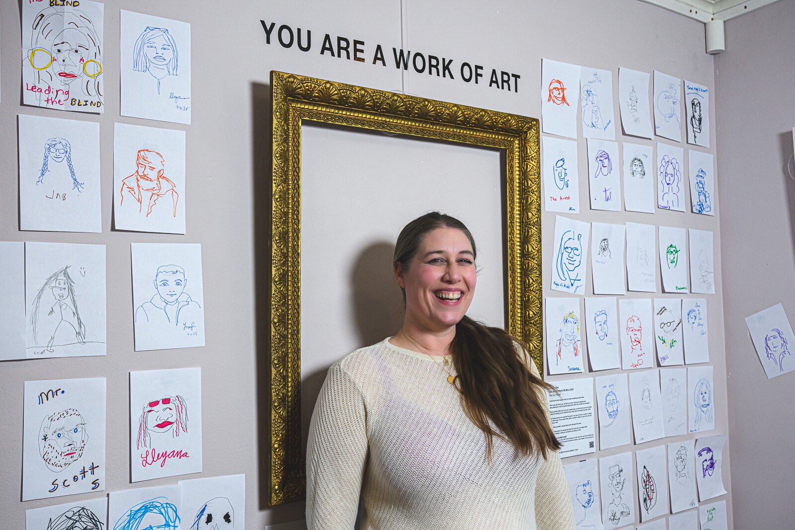 Sarah Nisbett with her exhibit "You Are A Work of Art" at Dzanc House.