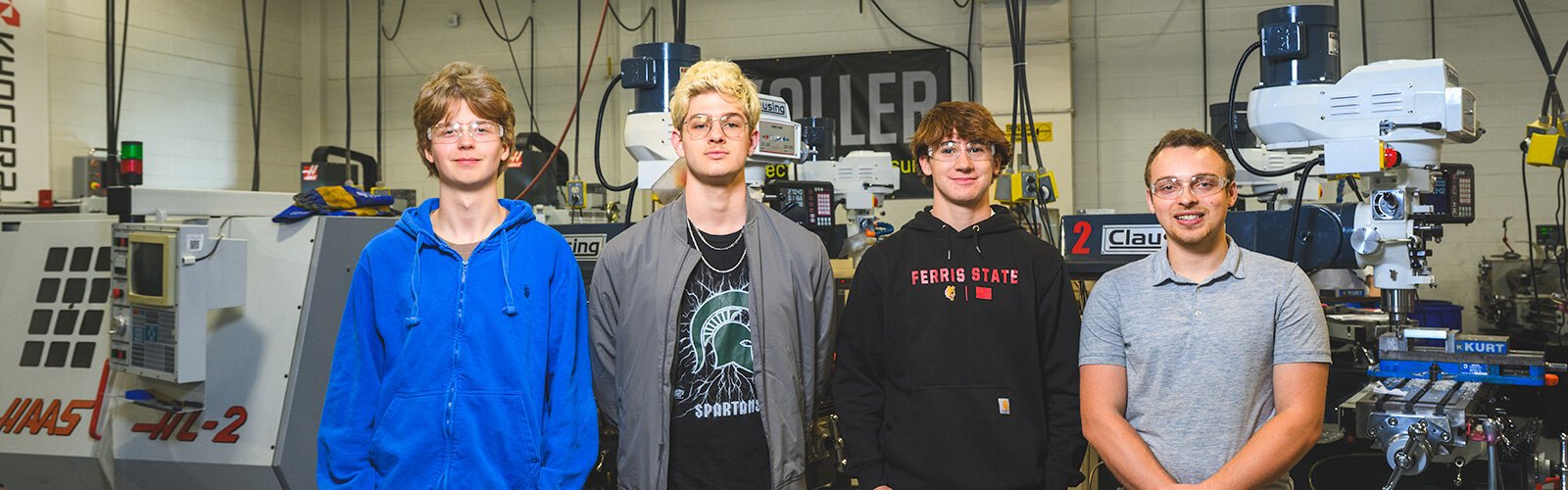Students Caleb Dahl, Jonah Bentley, and Ryan Friedholm with Computer Integrated Manufacturing instructor Trent Trout at Saline High School.