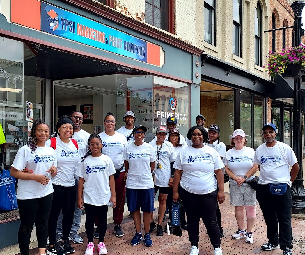 A Walk With Friends group prepares to set out on a two-mile walk around Ypsilanti on June 21, 2025.