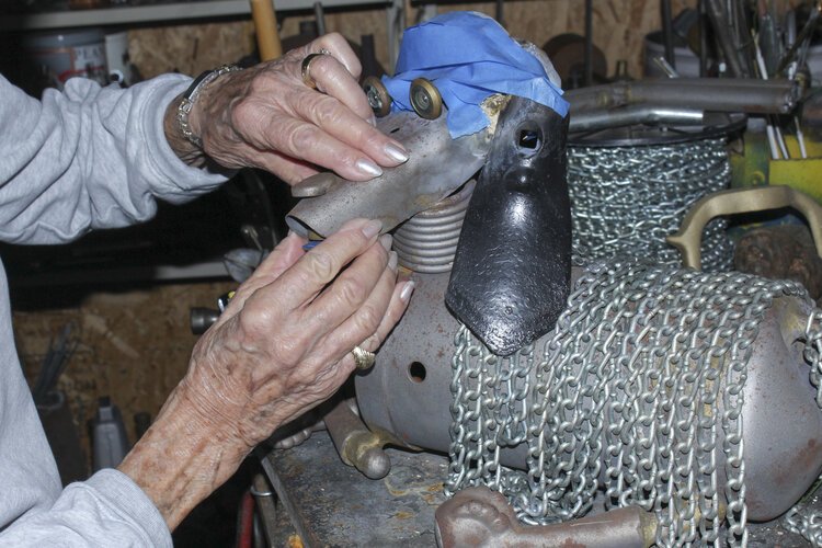 Rose Wunderbaum Traines works on a metal sculpture of a dog in her garage.