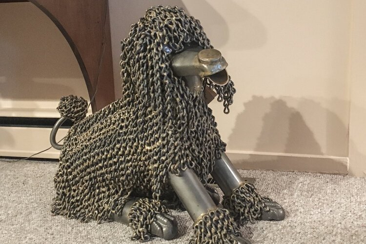 Weighing in around 120 pounds, this dog has a face made from a repurposed bicycle seat, “fur” crafted from chain, paws made of antique bath tub feet, and eyes that used to be peep holes on hotel room doors.