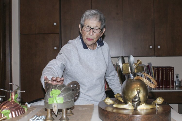 Rose Wunderbaum Traines works on metal sculptures on a counter in her kitchen.