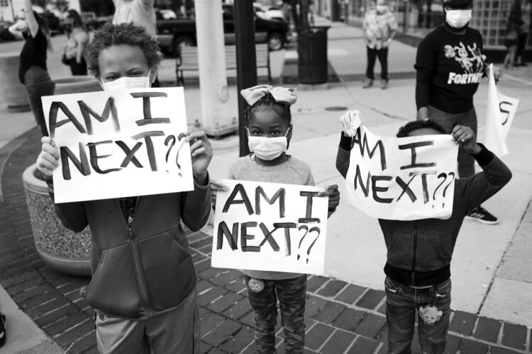 Children carried signs questioning their personal safety at a Bay City protest.