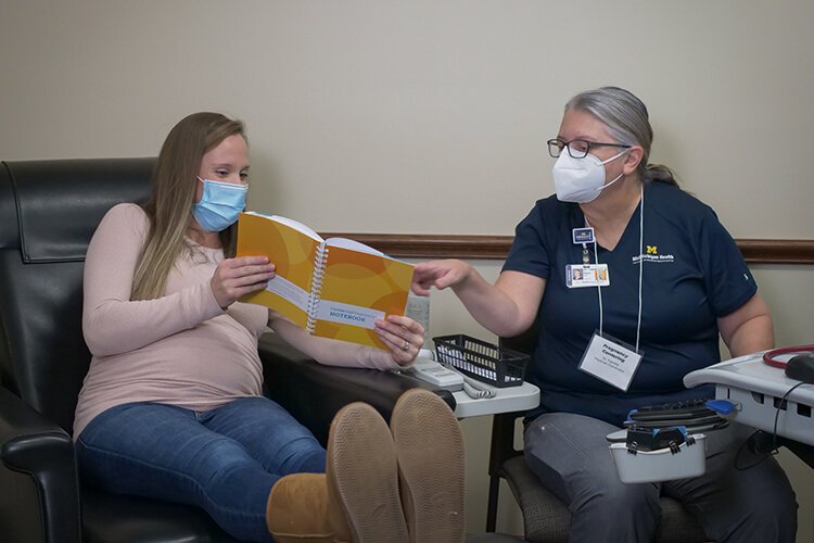 A pregnant patient reviews her vitals with Diane Traenkle, D.O., obstetrician/gynecologist and one of the Centering providers, during her belly check.