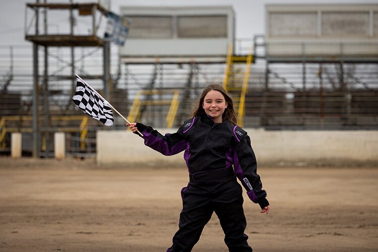 Ella Bringer waves the checkered flag on the race track. Taken at the Mt. Pleasant Speedway on March 22, 2022.