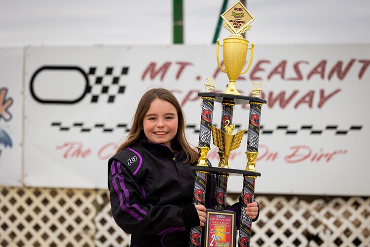 Ella Bringer poses with her trophy from last year’s racing season at the Mt. Pleasant Speedway. She was second in overall points.