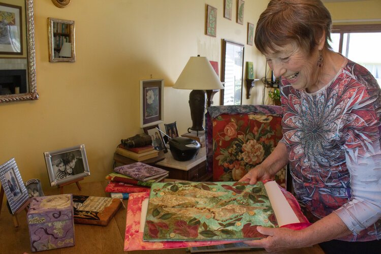 Virginia “Ginny” Crandall looks through a few of her sheer fabric collages.