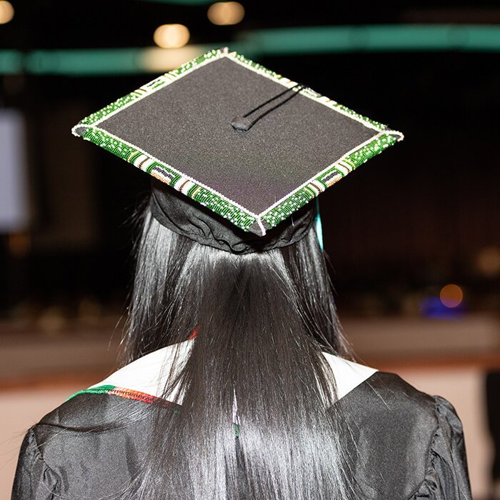 SCTC graduate displays her graduation cap, decorated with Native American beadwork.